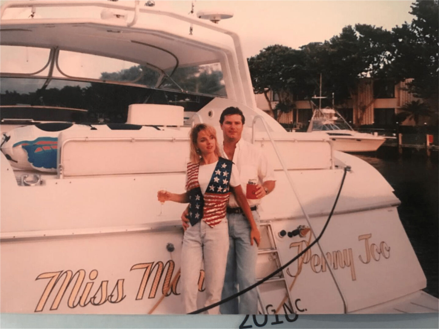 A couple taking a photo in front of a yacht