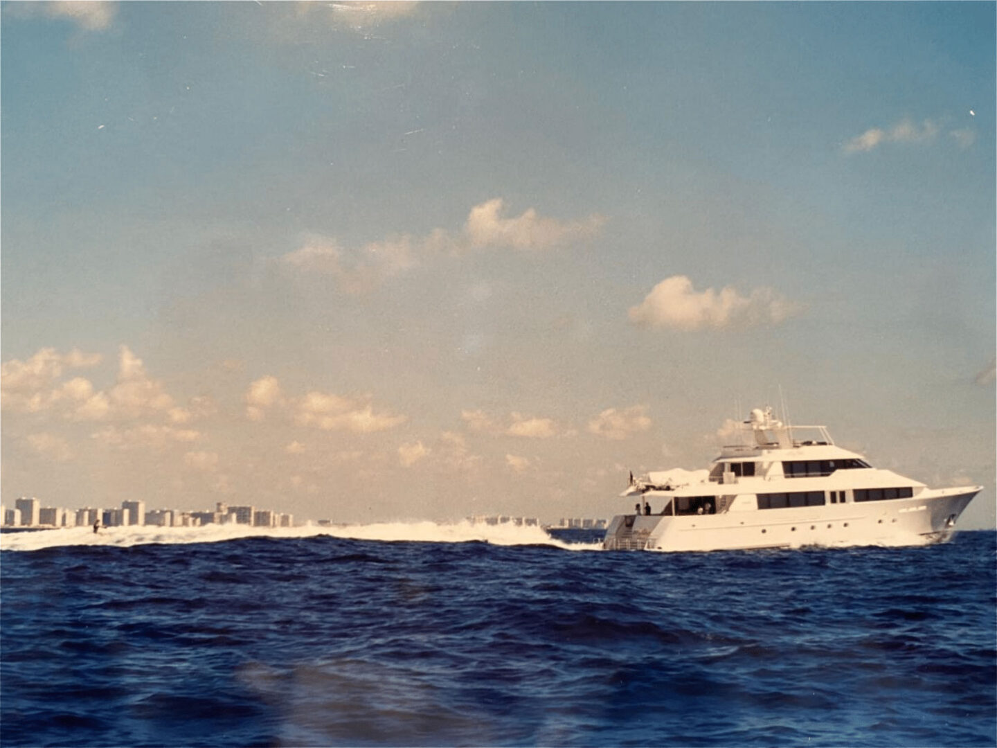 A yacht on the move with a water skiing person
