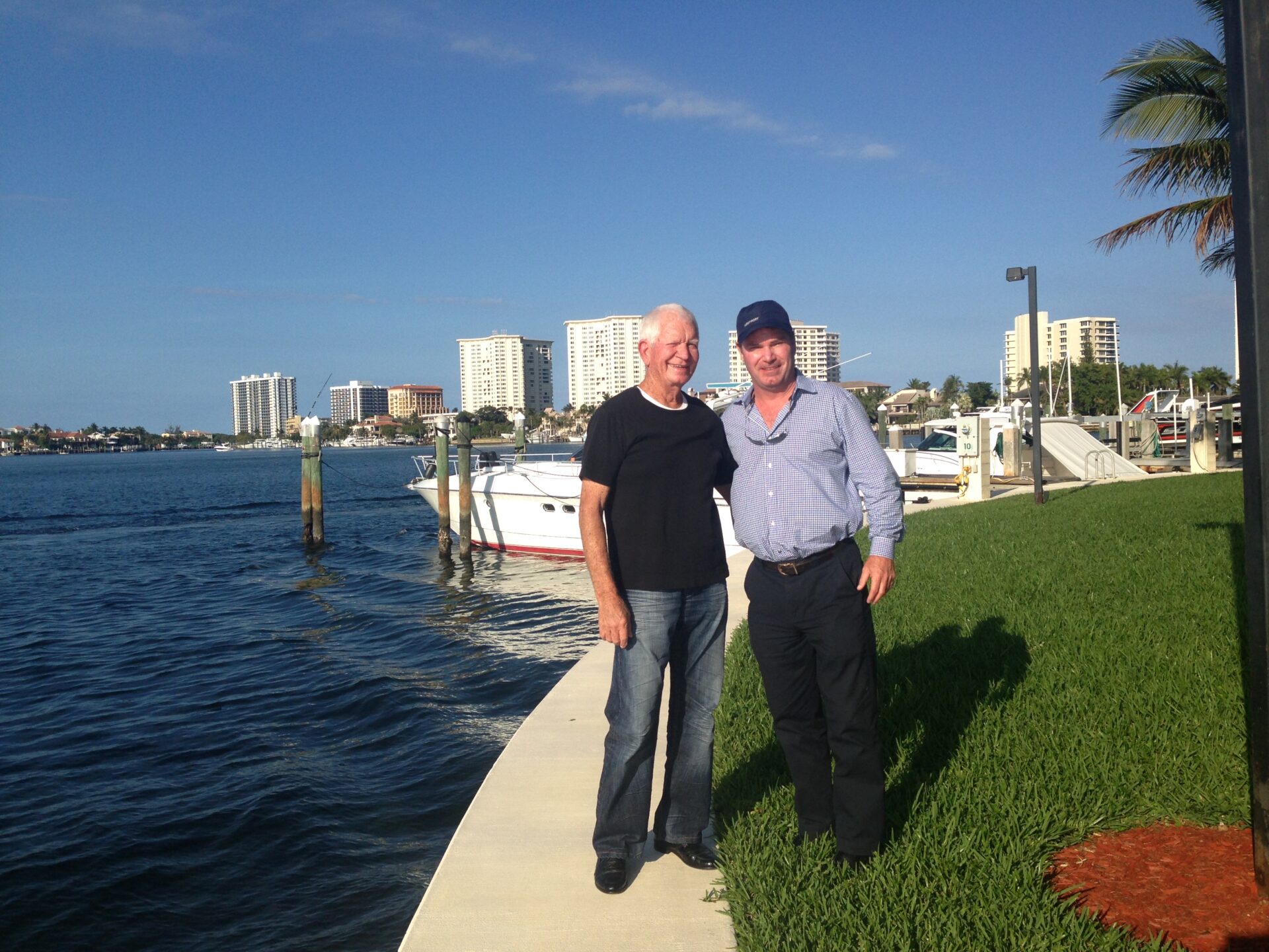 Two men standing by the yacht dock